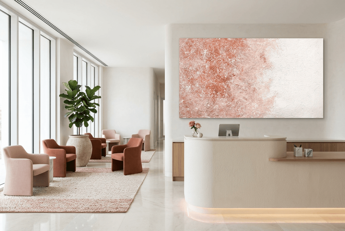 Coral Exposure abstract artwork with layered terracotta and coral pigment concentrated on the left, fading through blush into a broad chalk-white plaster-like field on the right in a private clinic with reception and waiting area