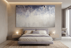 Overburden abstract artwork with a dark slate-violet plaster-like accumulation and fine drips above a chalk-white field with pale blue-grey veils in a modern hotel room