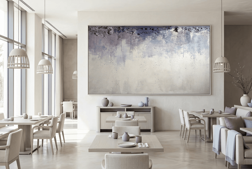Overburden abstract artwork with a dark slate-violet plaster-like accumulation and fine drips above a chalk-white field with pale blue-grey veils in a modern restaurant
