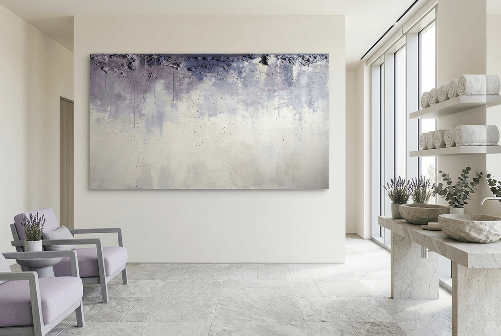 Overburden abstract artwork with a dark slate-violet plaster-like accumulation and fine drips above a chalk-white field with pale blue-grey veils in a wellness spa