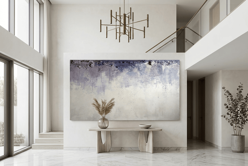 Overburden abstract artwork with a dark slate-violet plaster-like accumulation and fine drips above a chalk-white field with pale blue-grey veils in a two story foyer